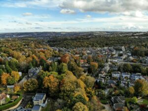 An aerial view of suburbs in the UK with lots of trees and houses